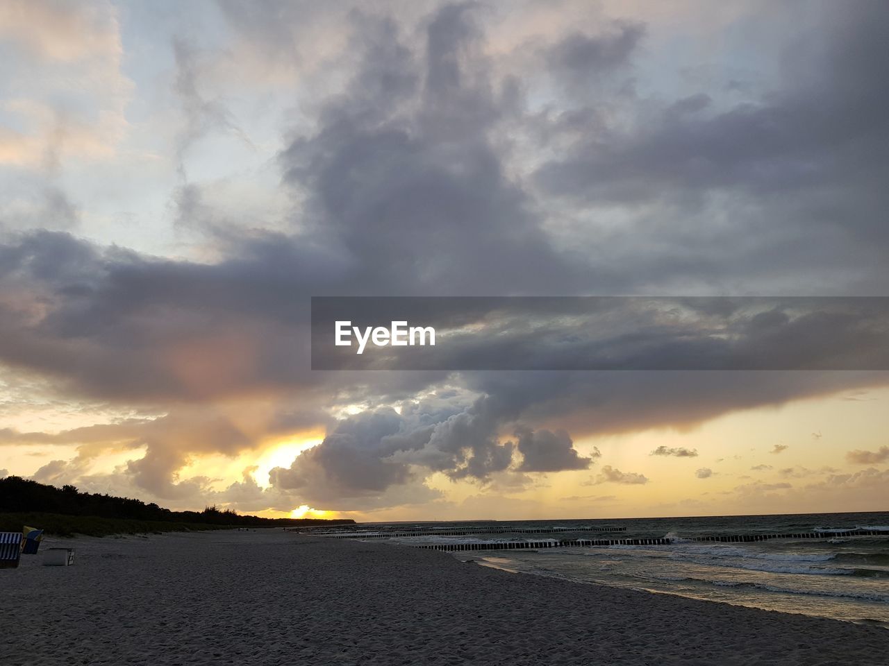 SCENIC VIEW OF BEACH AGAINST SKY AT SUNSET