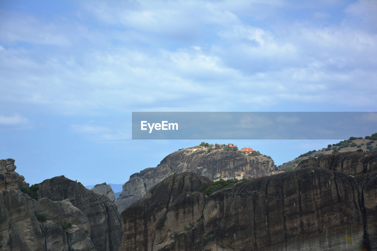 sky, rock, cloud, nature, travel destinations, environment, scenics - nature, mountain, travel, beauty in nature, landscape, land, cliff, no people, rock formation, outdoors, tourism, terrain, blue, architecture, day, non-urban scene, mountain range, tranquility, tranquil scene