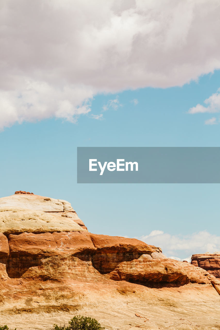 Layers of red sandstone formation under sunny skies in utah desert