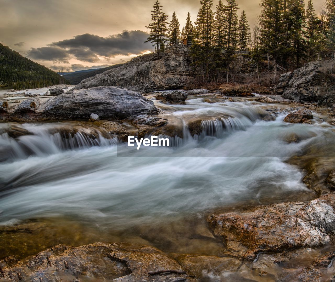 SCENIC VIEW OF STREAM FLOWING THROUGH ROCKS IN FOREST