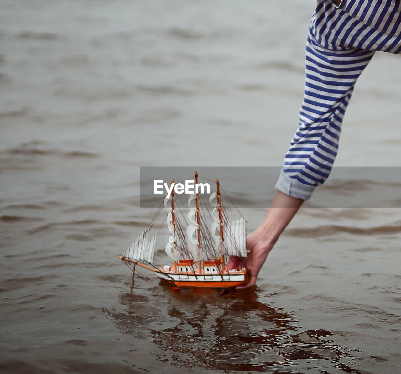 Woman putting boat on sea