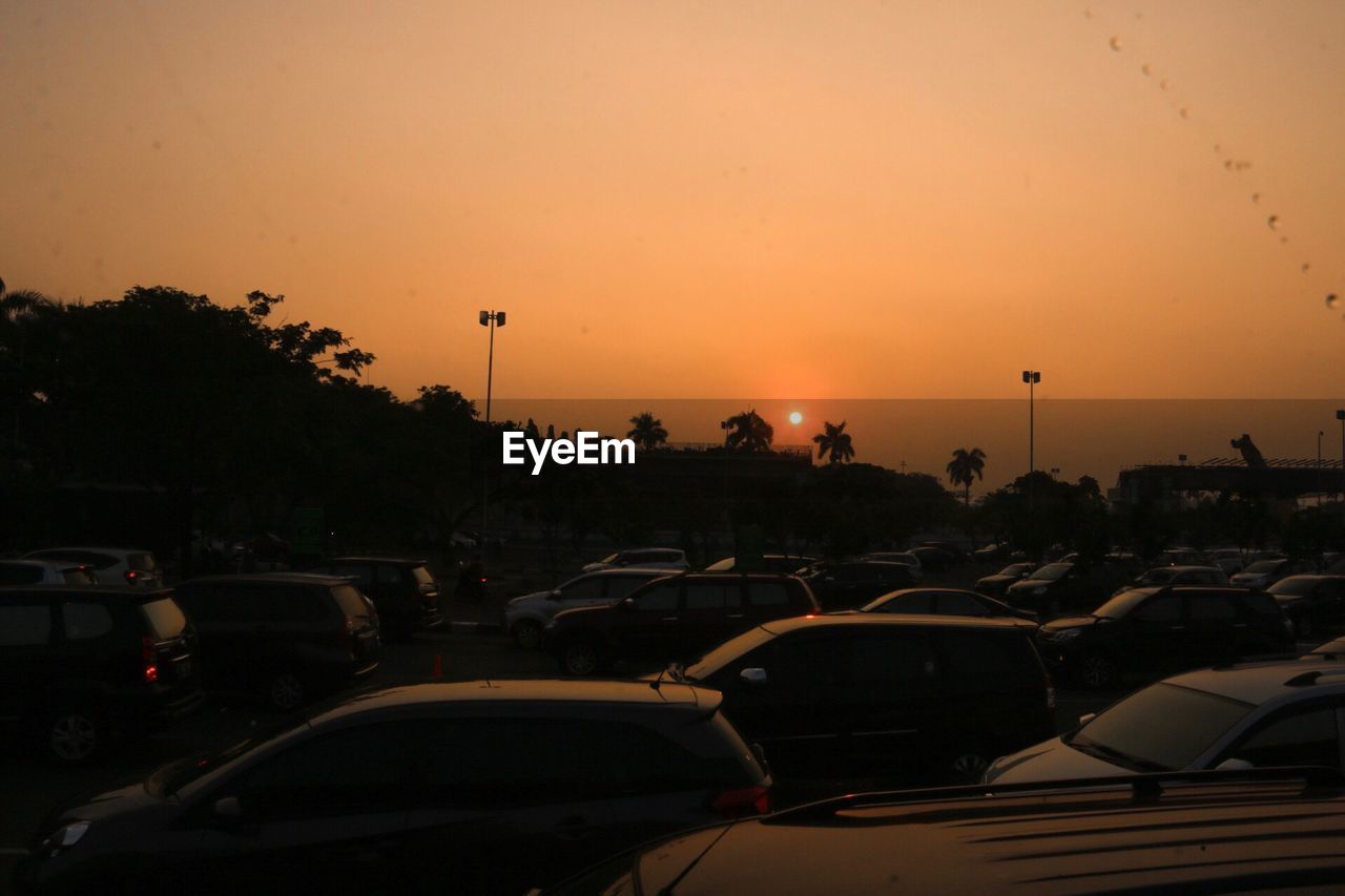 CARS ON CITY AGAINST SKY AT SUNSET