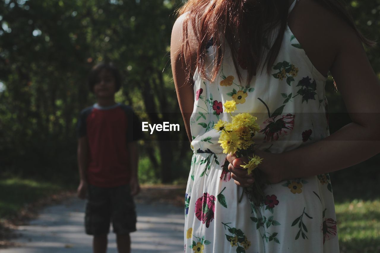 Rear view of girl holding flowers