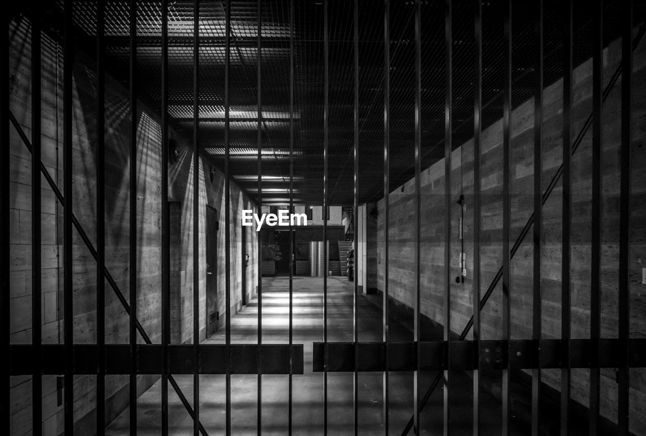 darkness, architecture, black, built structure, light, indoors, black and white, building, monochrome, line, no people, prison, monochrome photography, punishment, metal, prison cell, day, white, railing, pattern, security, arcade, corridor