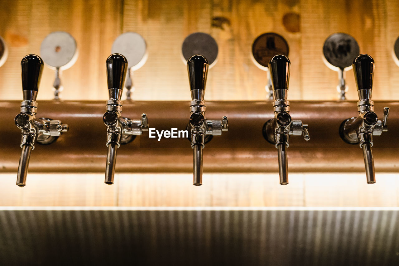 Close-up of beer taps at bar counter