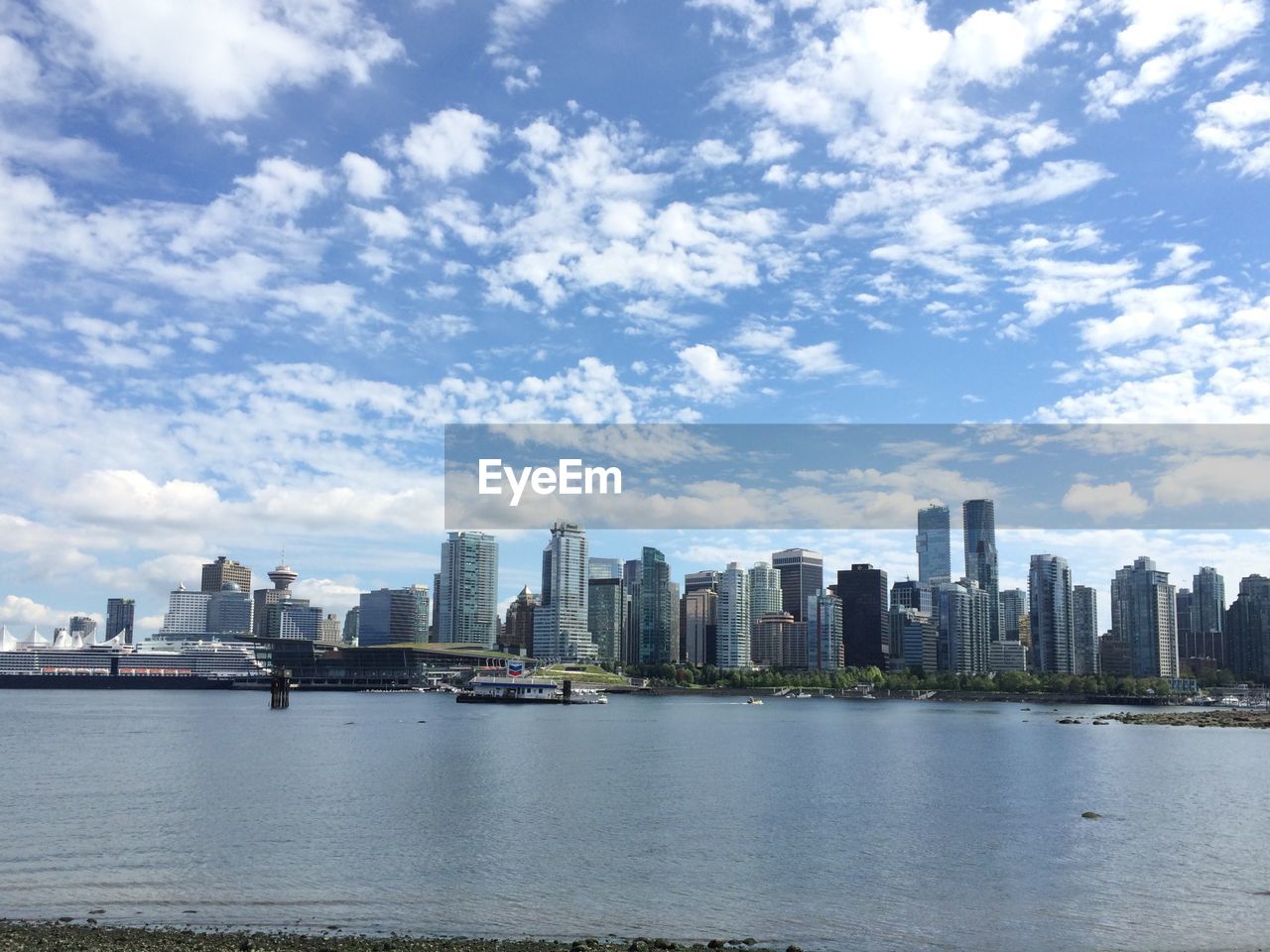 RIVER BY CITY SKYLINE AGAINST SKY