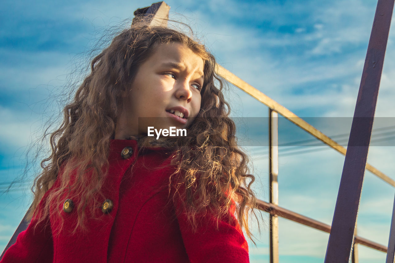 child, women, childhood, one person, hairstyle, sky, long hair, curly hair, red, nature, portrait, female, blue, sea, emotion, happiness, smiling, brown hair, water, looking, clothing, cloud, photo shoot, leisure activity, wind, fun, holiday, person, lifestyles, positive emotion, cute, outdoors, trip, vacation, summer, sunlight, enjoyment, cheerful, day, carefree, waist up, adult, standing, nautical vessel, looking away, beauty in nature, joy