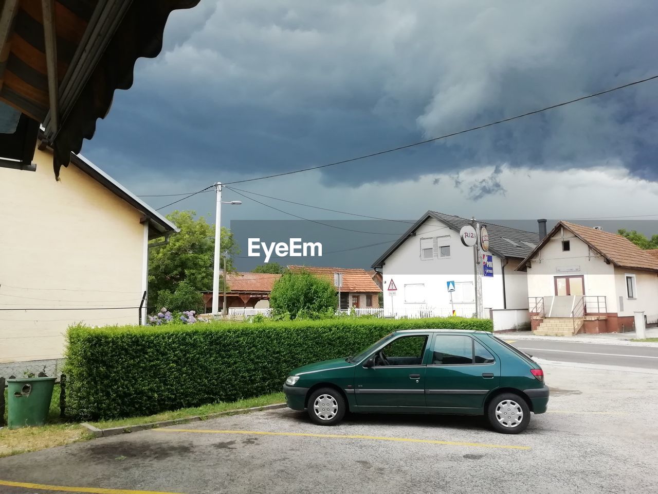 CAR ON ROAD BY BUILDINGS AGAINST SKY