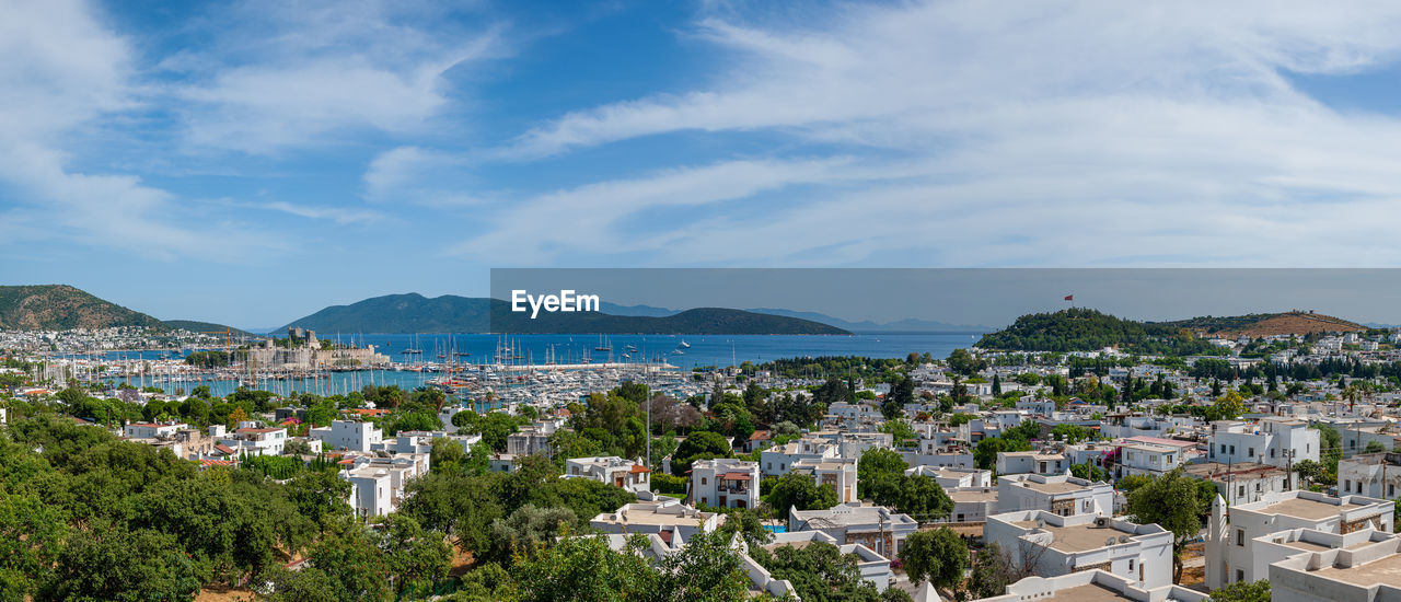 Panoramic view at bodrum town with harbor. yachts and sail boats anchored in bay waters. turkey.