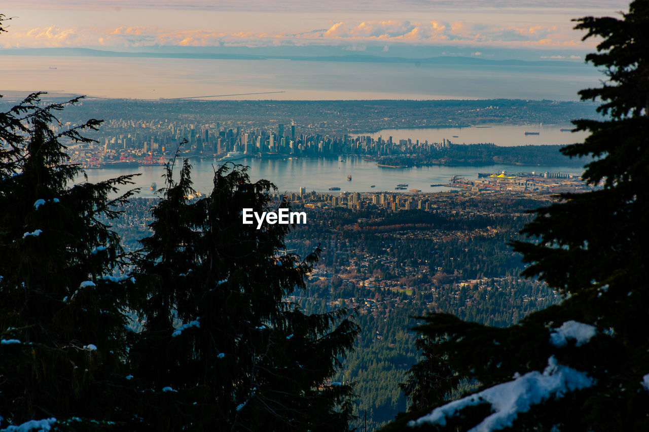 High angle view of cityscape by sea against sky