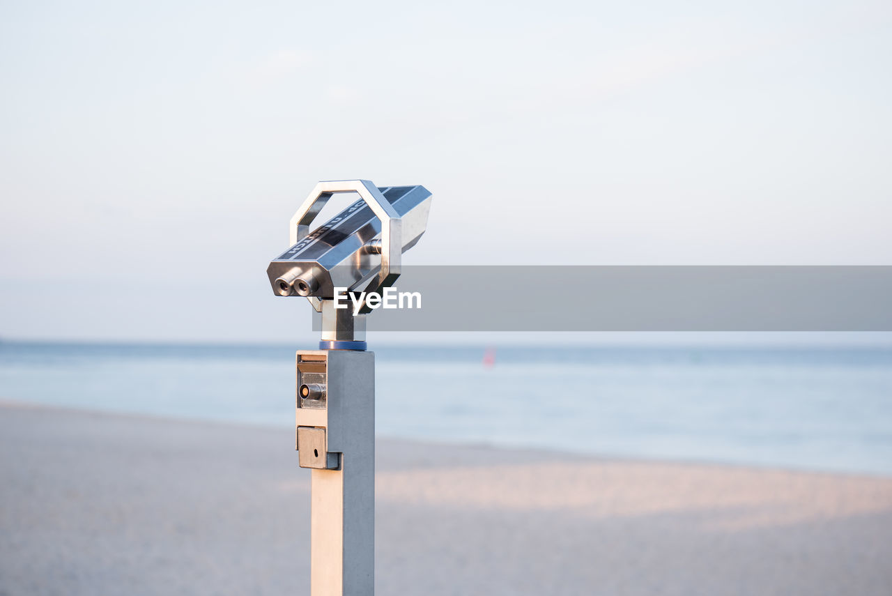 CLOSE-UP OF COIN-OPERATED BINOCULARS ON BEACH