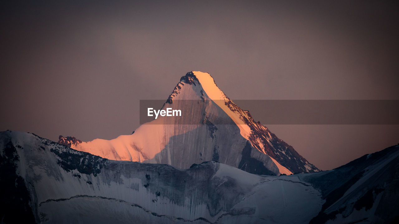 SCENIC VIEW OF SNOWCAPPED MOUNTAIN AGAINST SKY DURING SUNSET