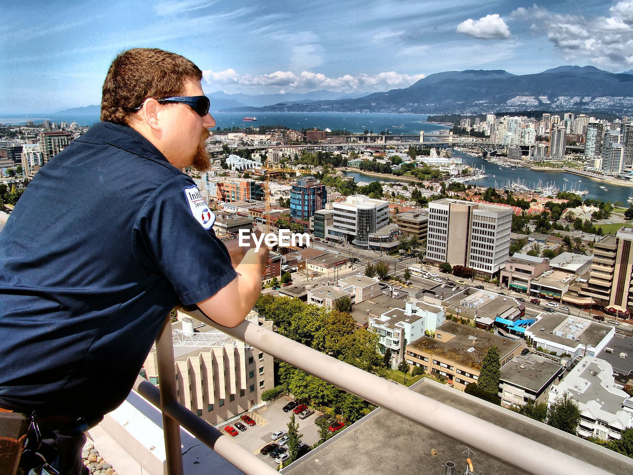 HIGH ANGLE VIEW OF WOMAN STANDING ON CITYSCAPE