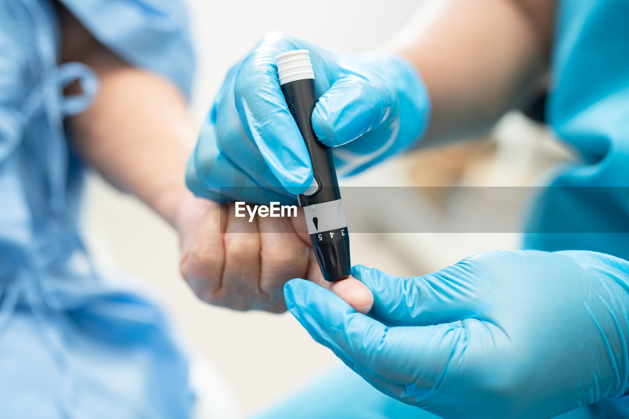 midsection of doctor holding dental equipment in hospital