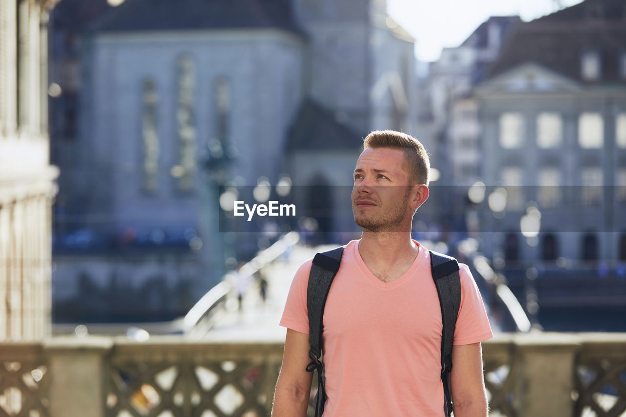 Portrait of man standing against city