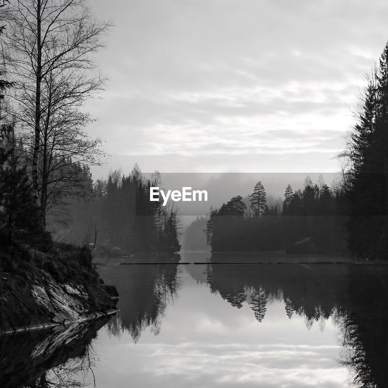 SCENIC VIEW OF CALM LAKE AGAINST CLOUDY SKY