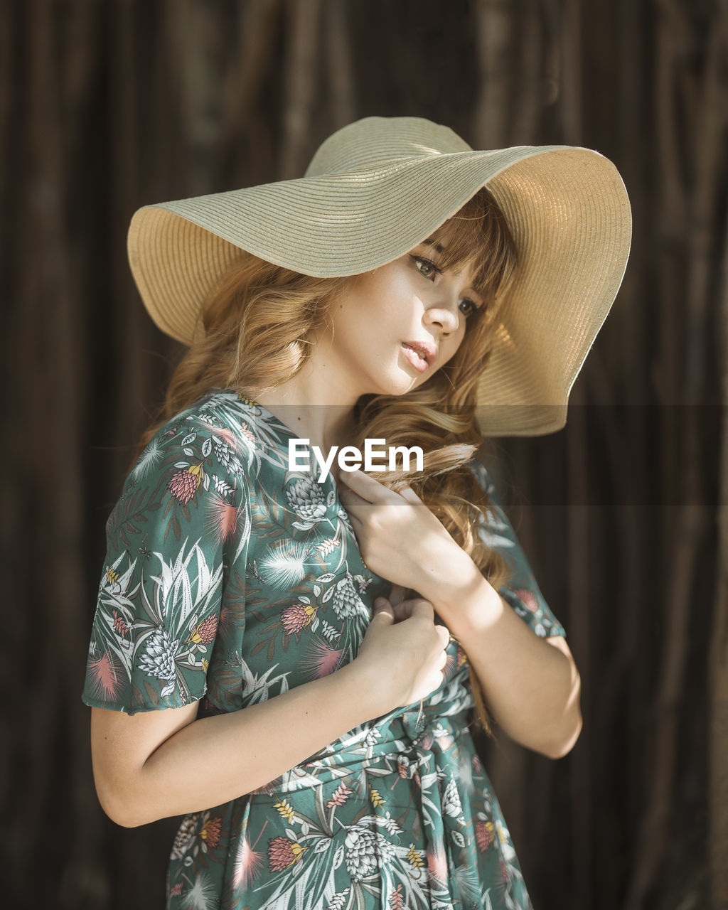 Thoughtful young woman looking away while wearing hat outdoors