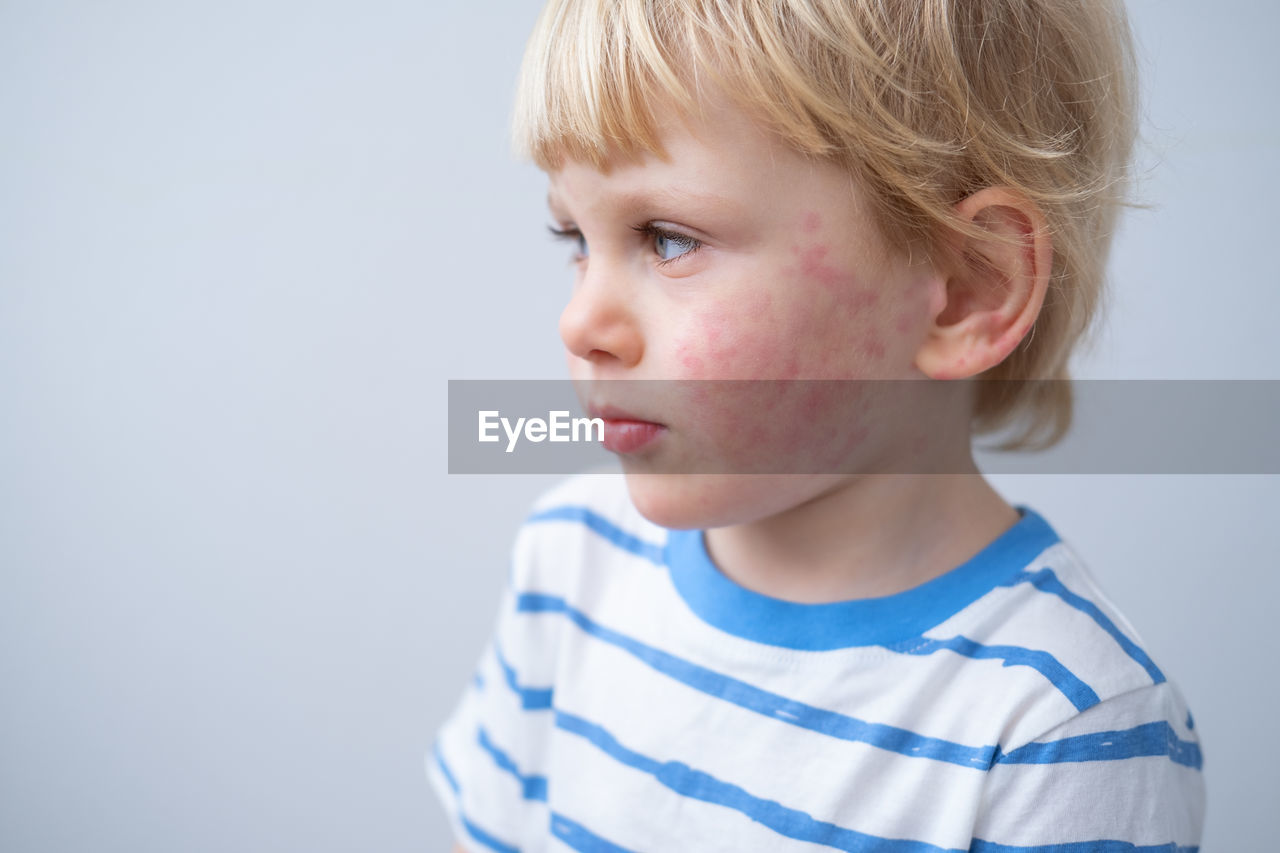 close-up portrait of cute boy against wall