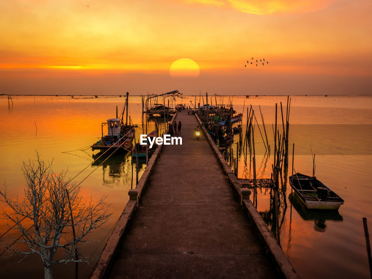 PIER OVER SEA AGAINST ORANGE SKY