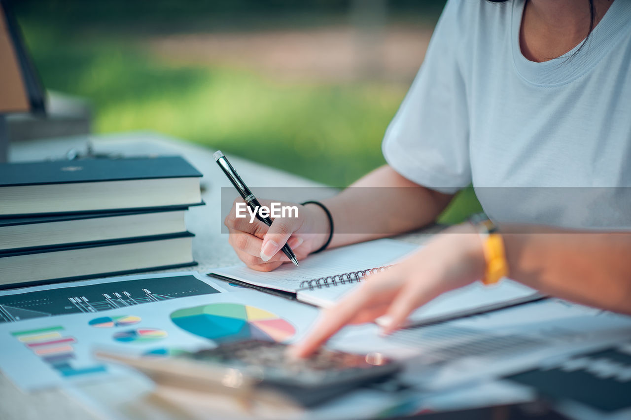 Close-up of businesswoman working at desk in office