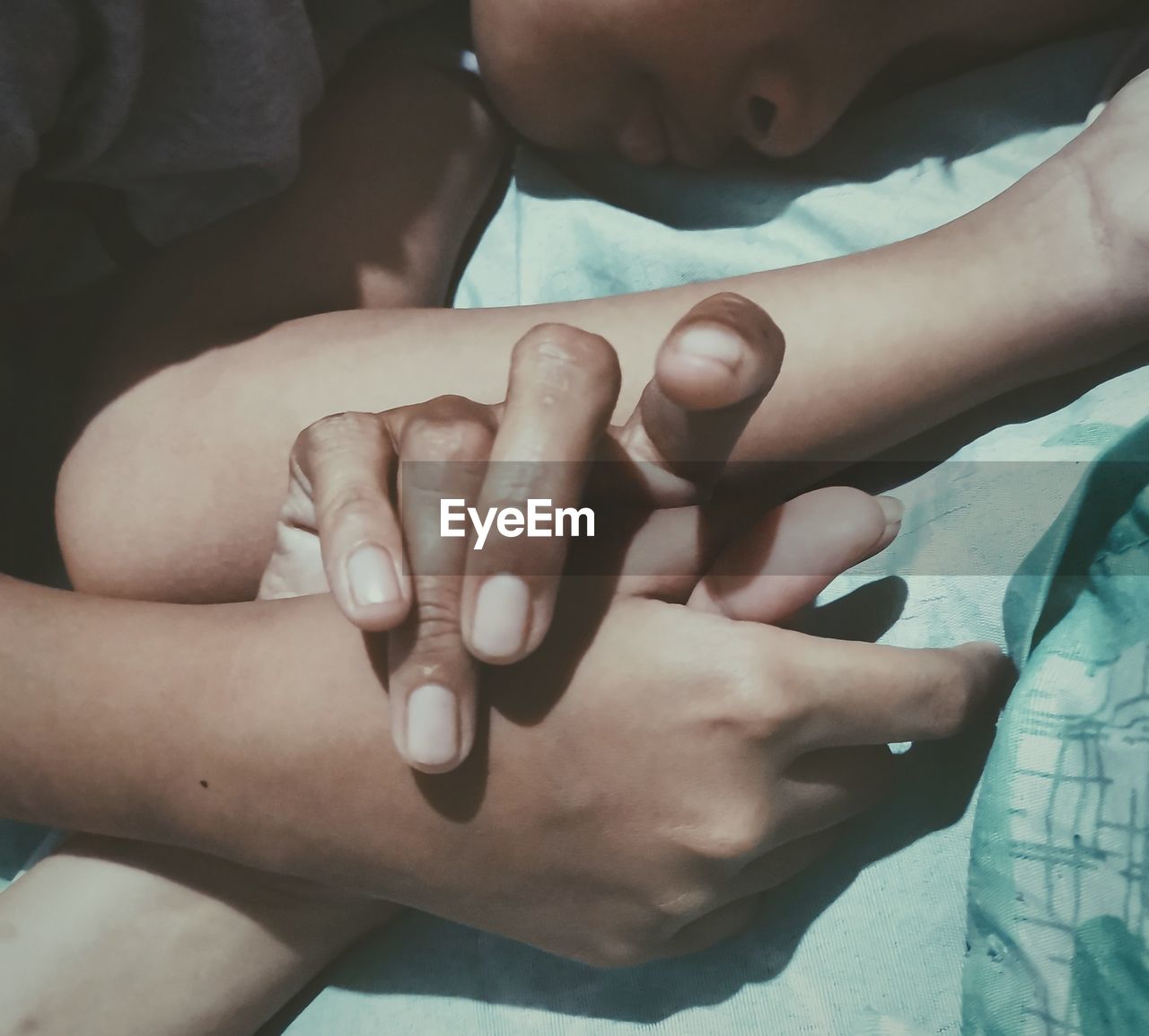 Midsection of boy holding mother hand