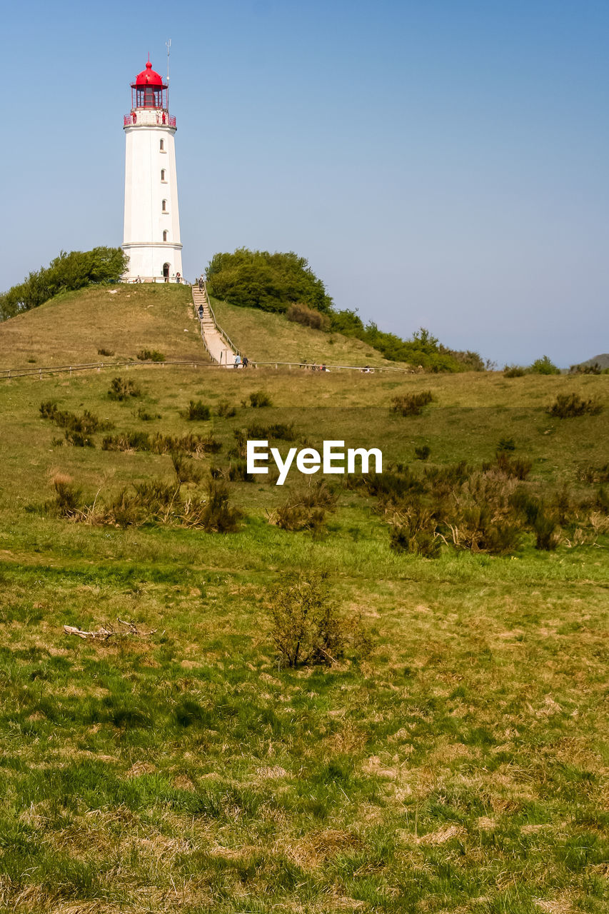 Low angle view of lighthouse on hill against sky