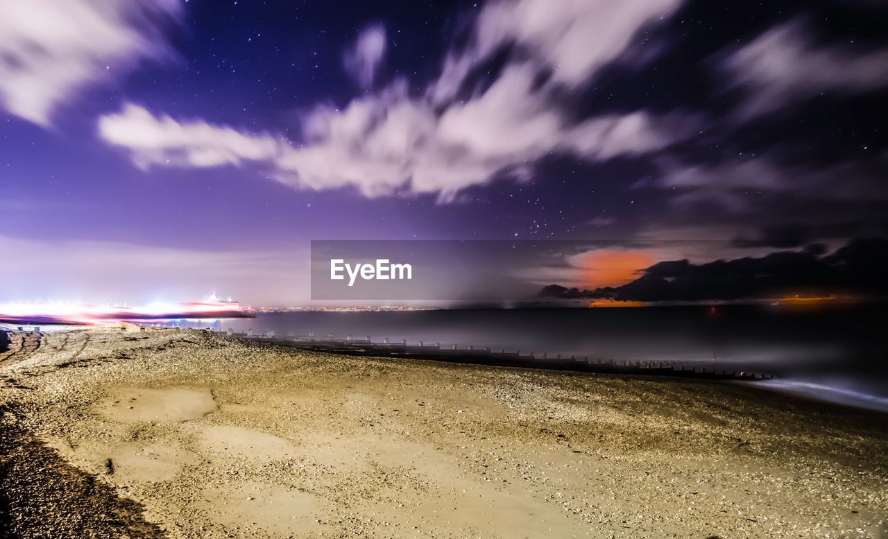 SCENIC VIEW OF BEACH AGAINST SKY AT NIGHT