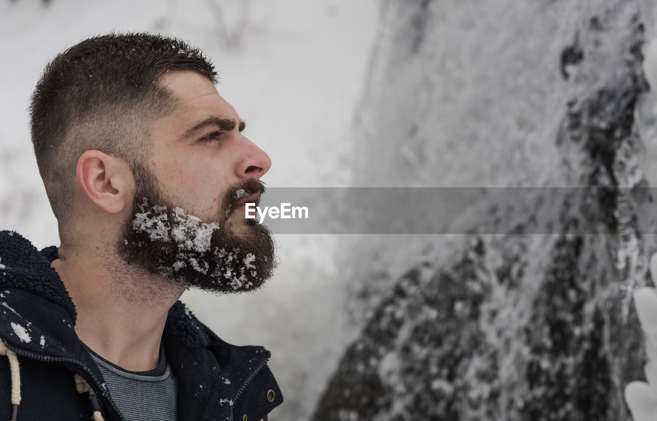 side view of young man looking at waterfall