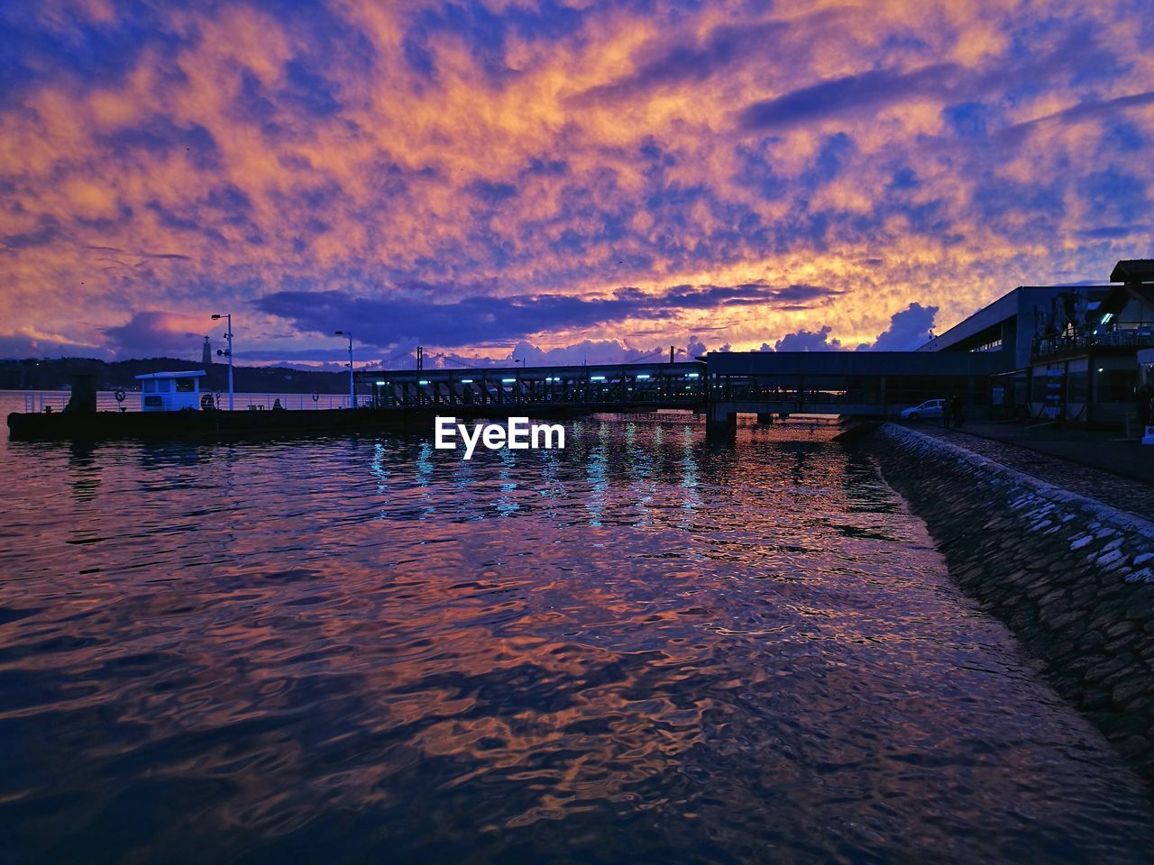 Bridge over river against sky during sunset