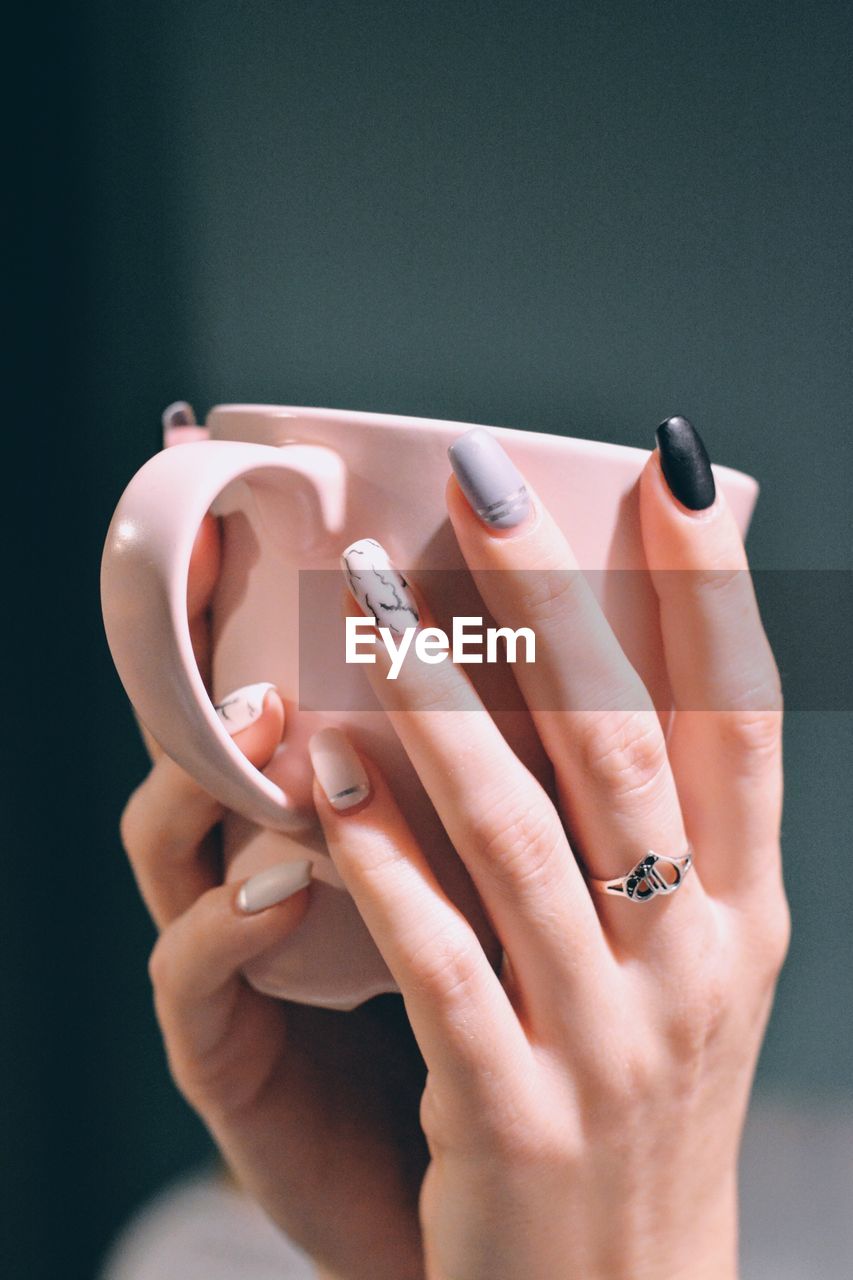 Cropped hands of woman holding mug