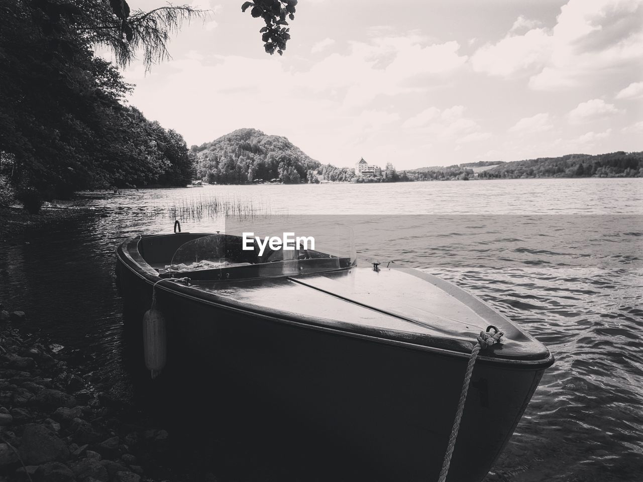 Boat moored in lake against sky