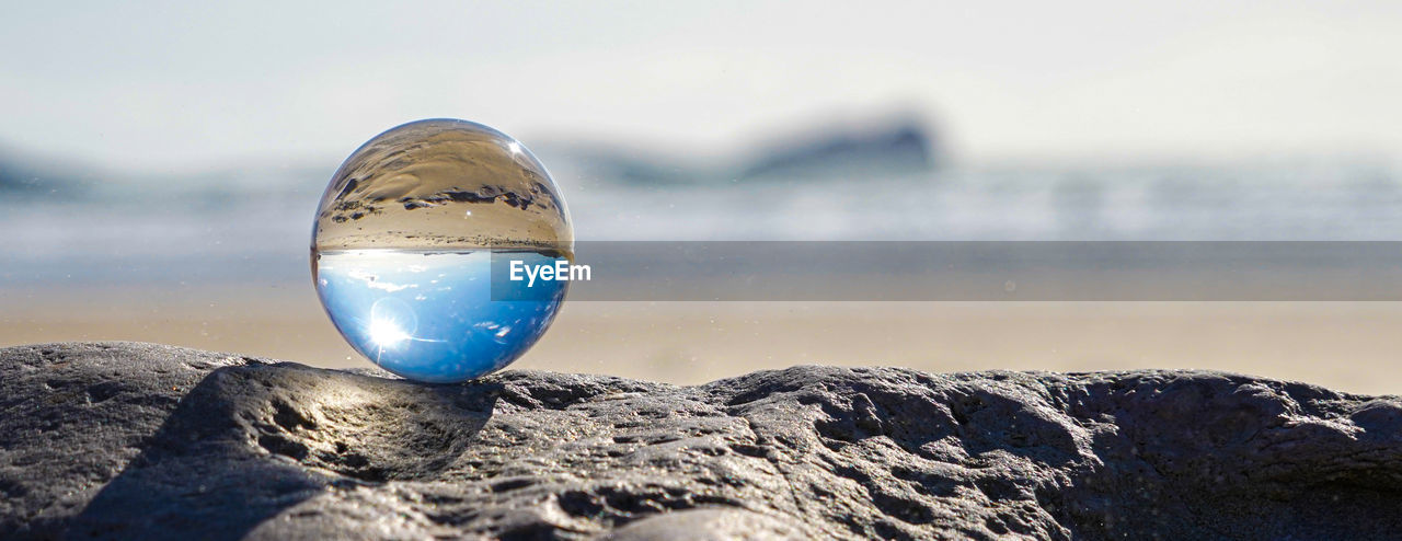 CLOSE-UP OF CRYSTAL BALL ON ROCKS