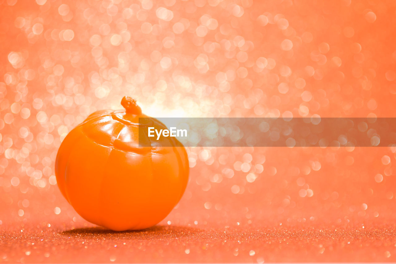 CLOSE-UP OF ORANGE SLICE OVER RED BACKGROUND