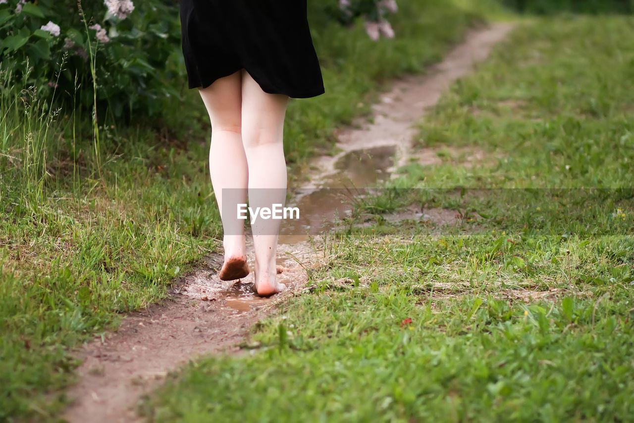 Low section of woman walking on footpath