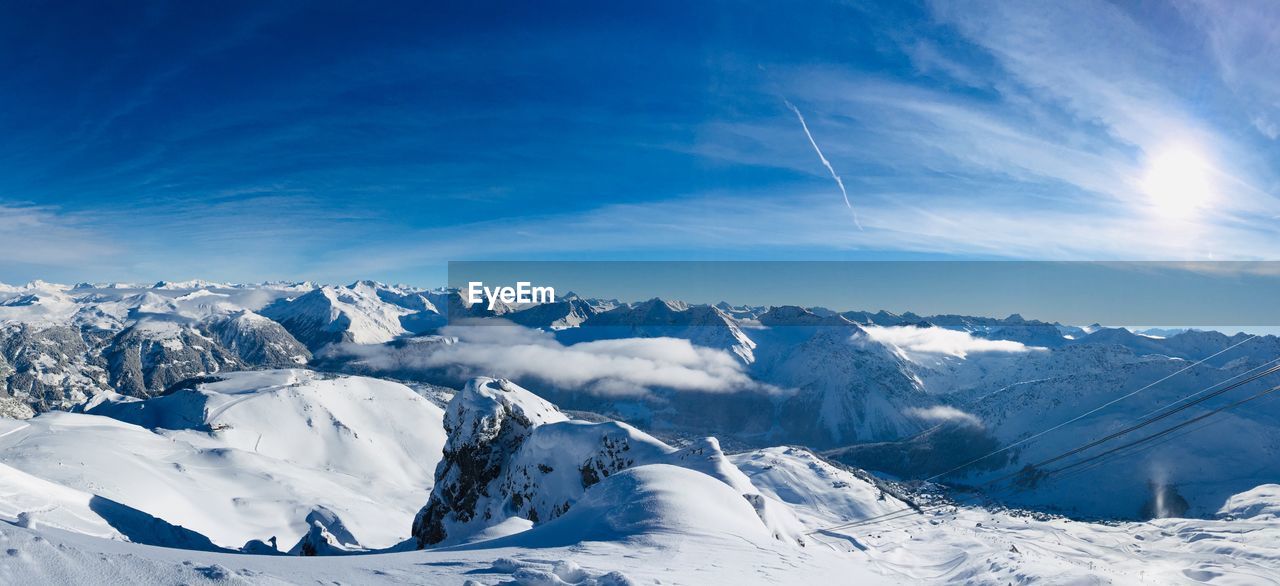 Scenic view of snowcapped mountains against blue sky