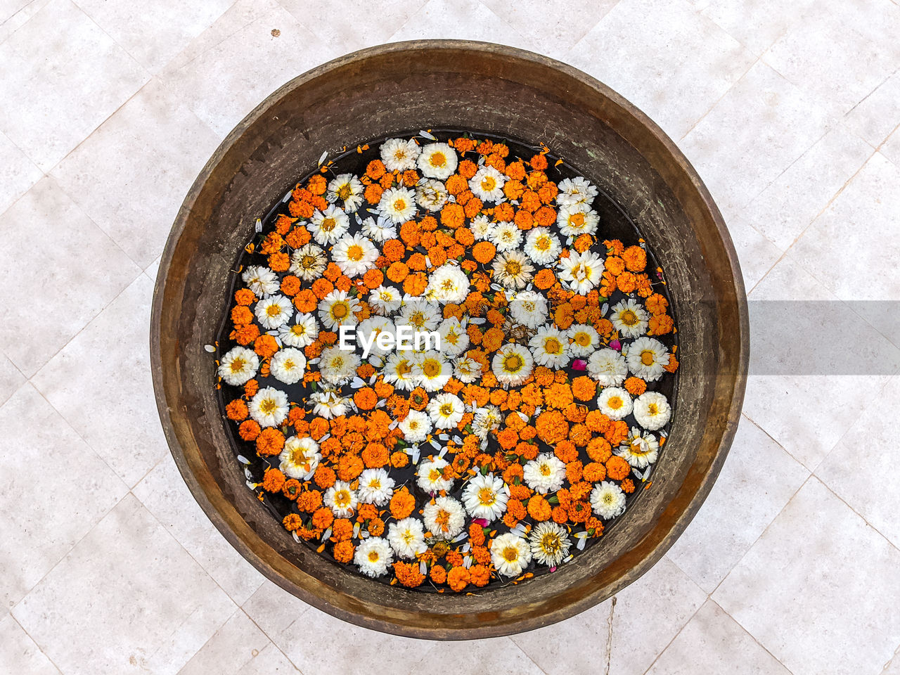 High angle view of flower heads swimming in large bowl on floor