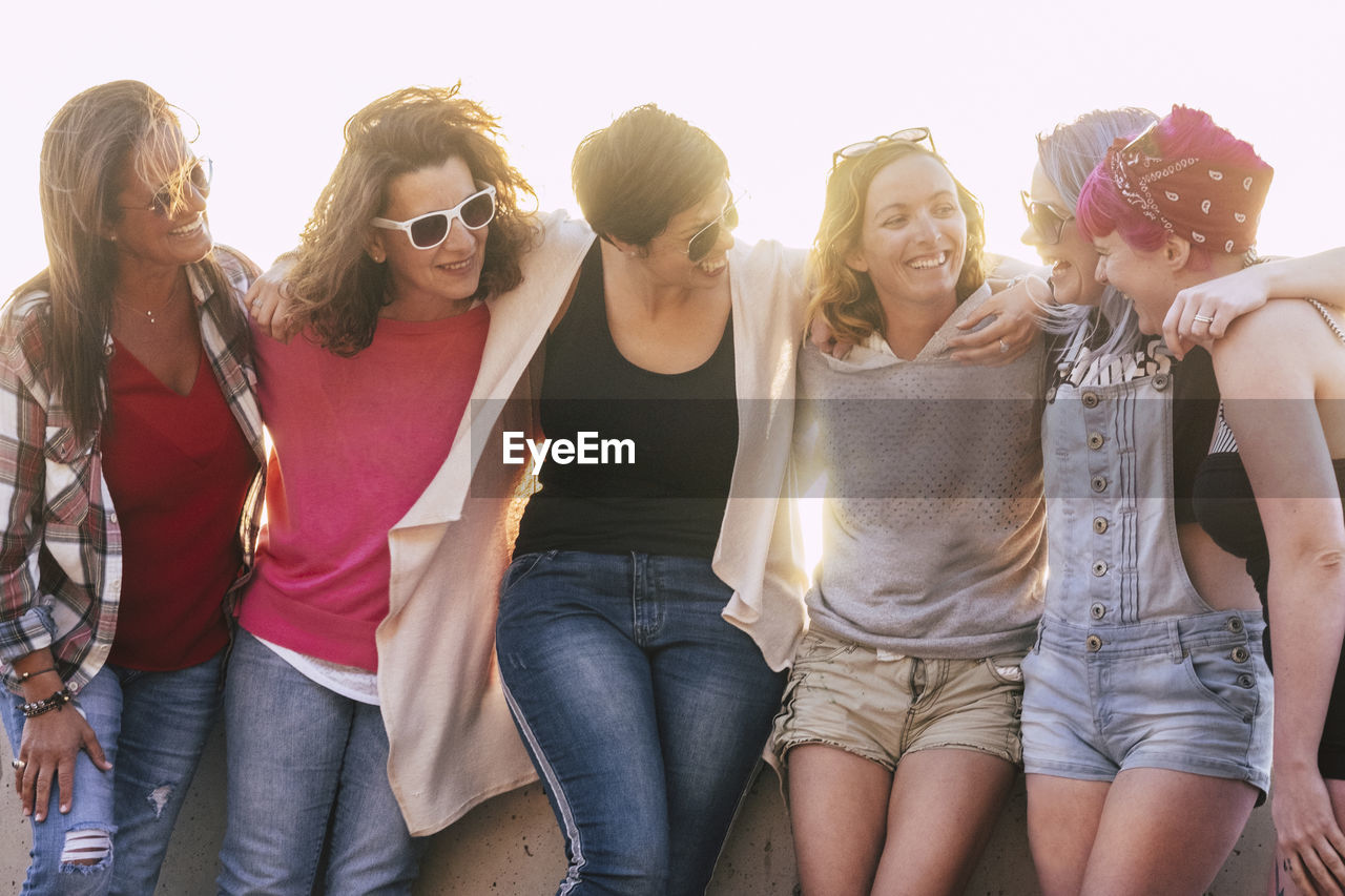 GROUP OF PEOPLE WEARING SUNGLASSES AGAINST THE SKY