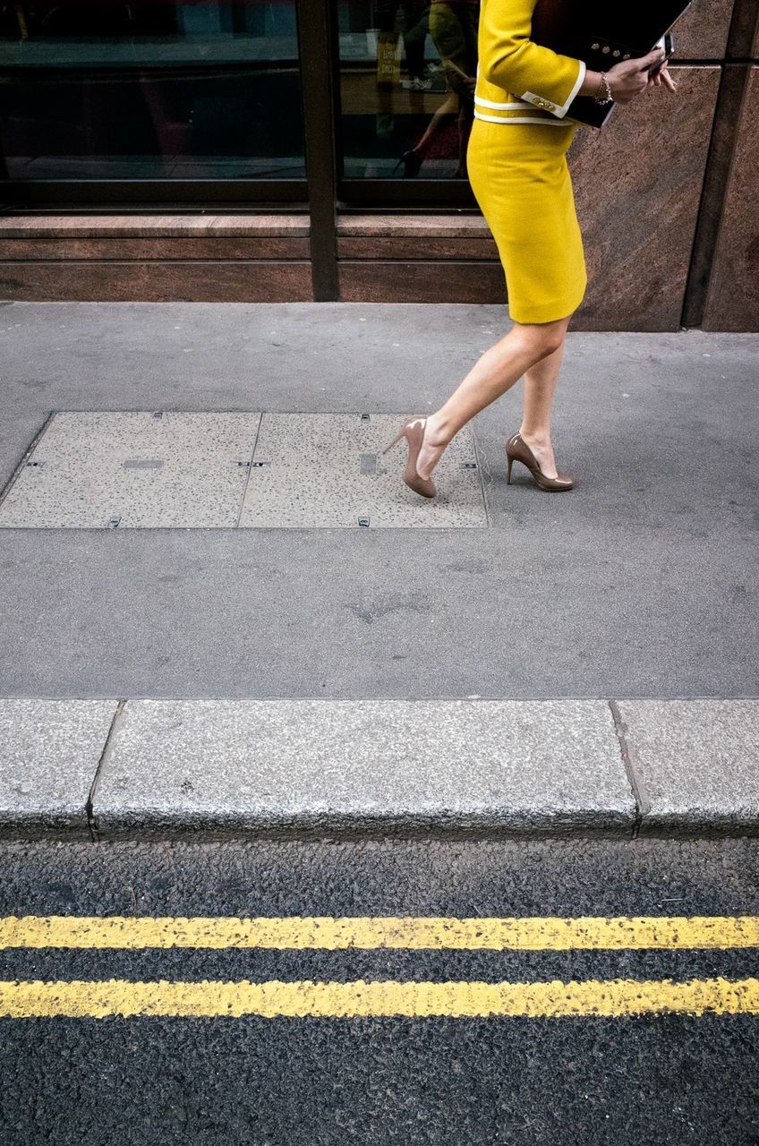 LOW SECTION OF WOMAN WALKING ON STREET