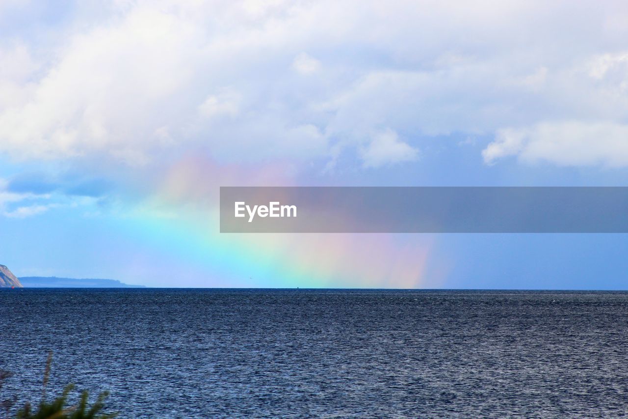VIEW OF RAINBOW OVER SEA AGAINST SKY