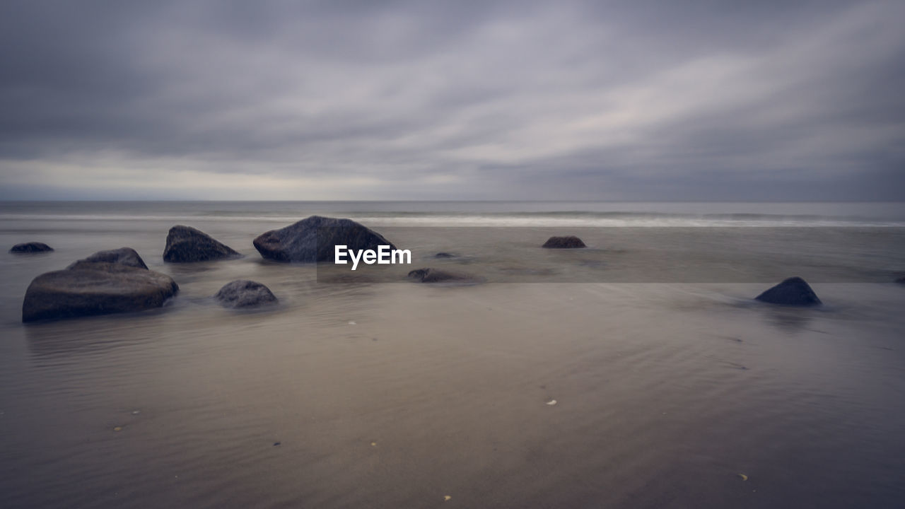 ROCKS IN SEA AGAINST SKY