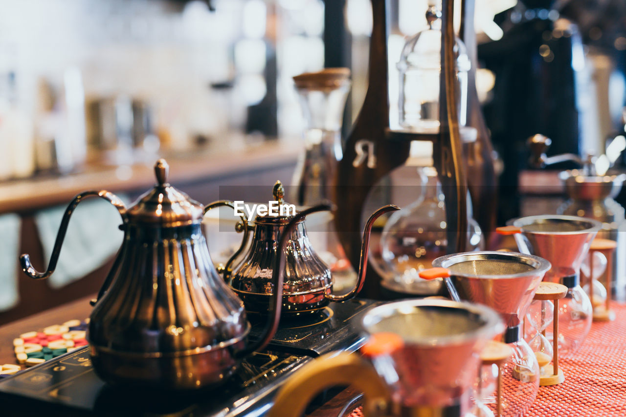 Close-up of teapots with coffee makers on table