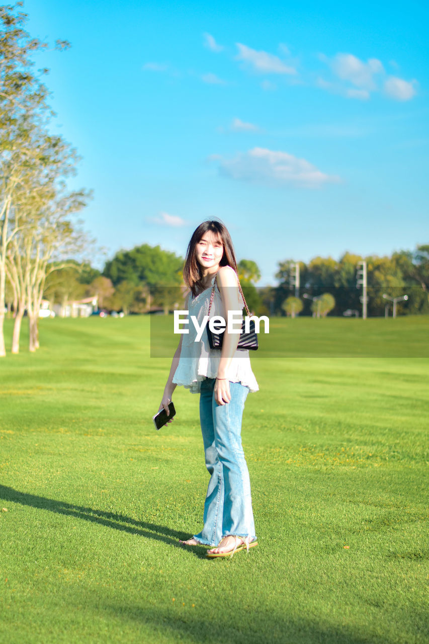 Side view of young woman standing on field