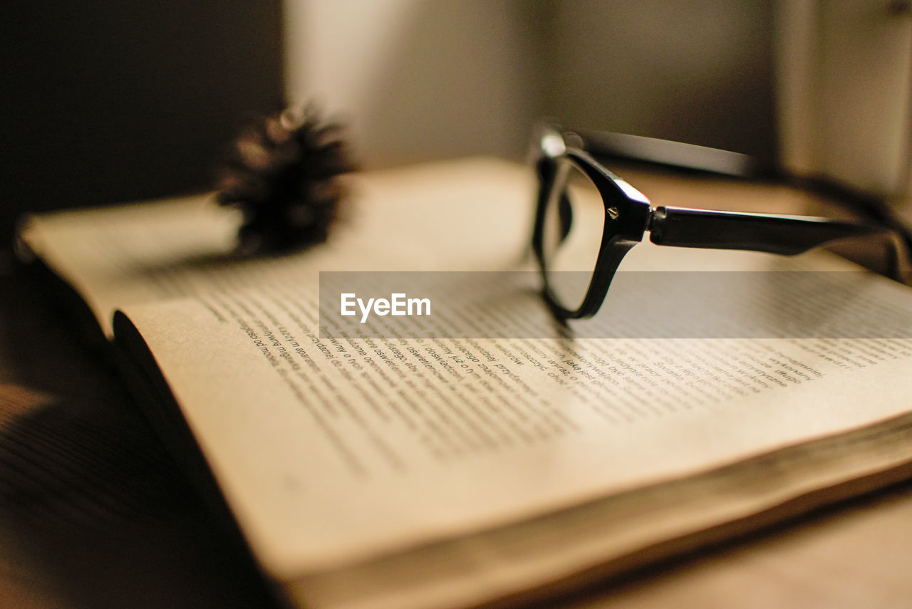 CLOSE-UP OF OPEN BOOK WITH TEXT ON TABLE