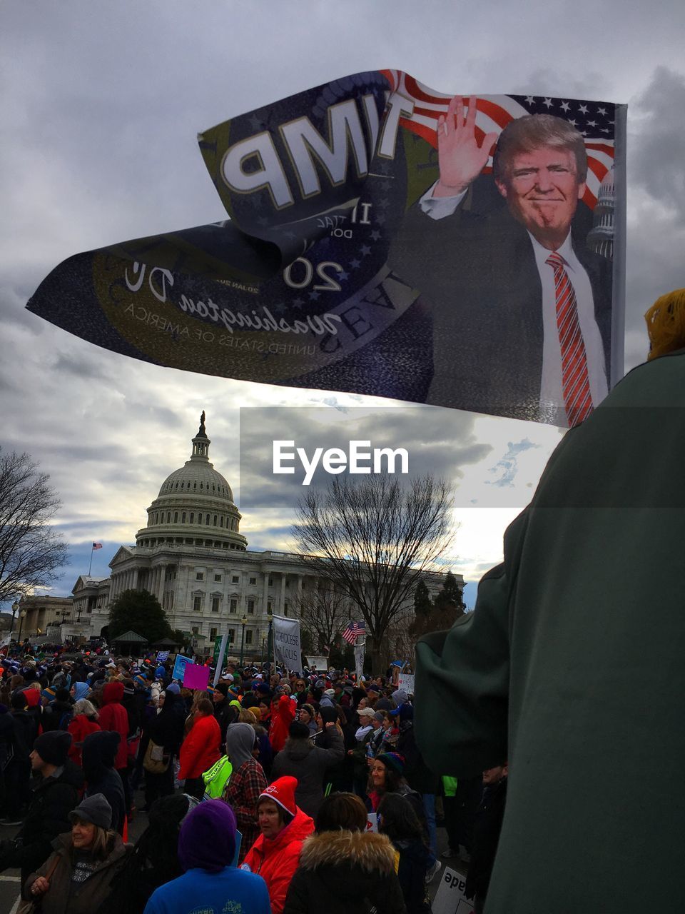 MIDSECTION OF MAN WITH UMBRELLA IN BACKGROUND