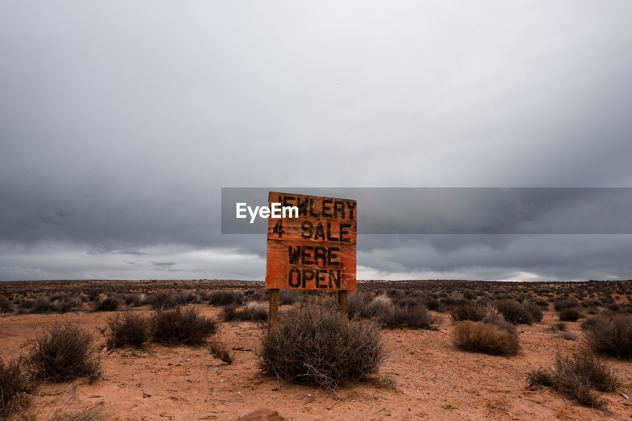 Information sign at monument valley against cloudy sky in arizona