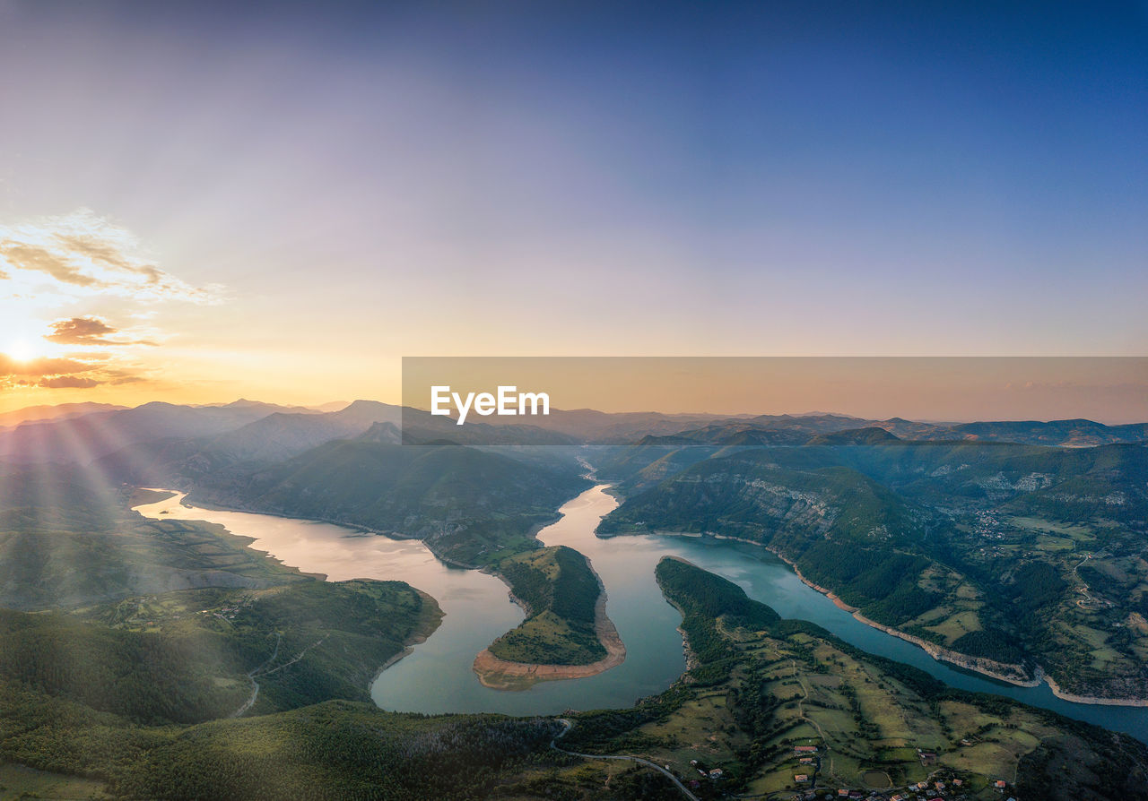 SCENIC VIEW OF MOUNTAINS AGAINST SKY AT SUNSET