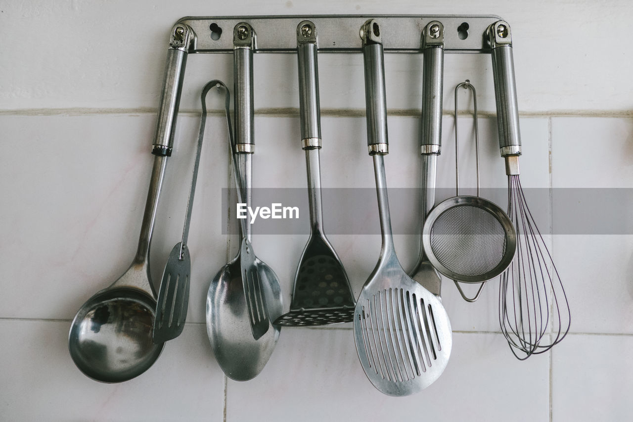 Utensils hanging on hook against wall in kitchen