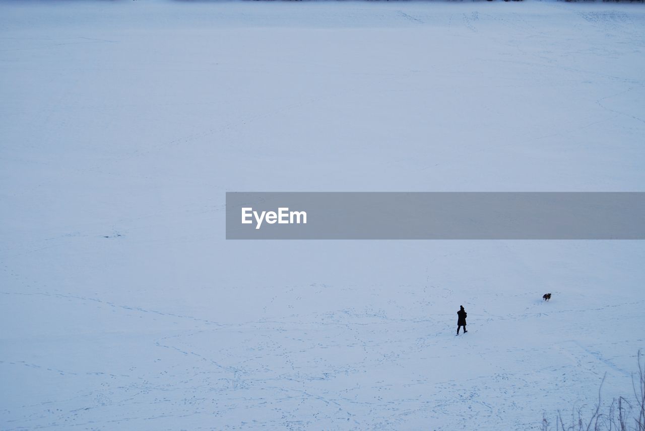 HIGH ANGLE VIEW OF PEOPLE SKIING ON SNOW