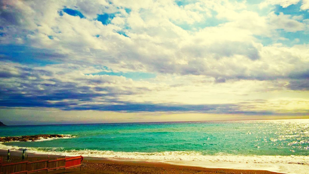 VIEW OF CALM BEACH AGAINST CLOUDS