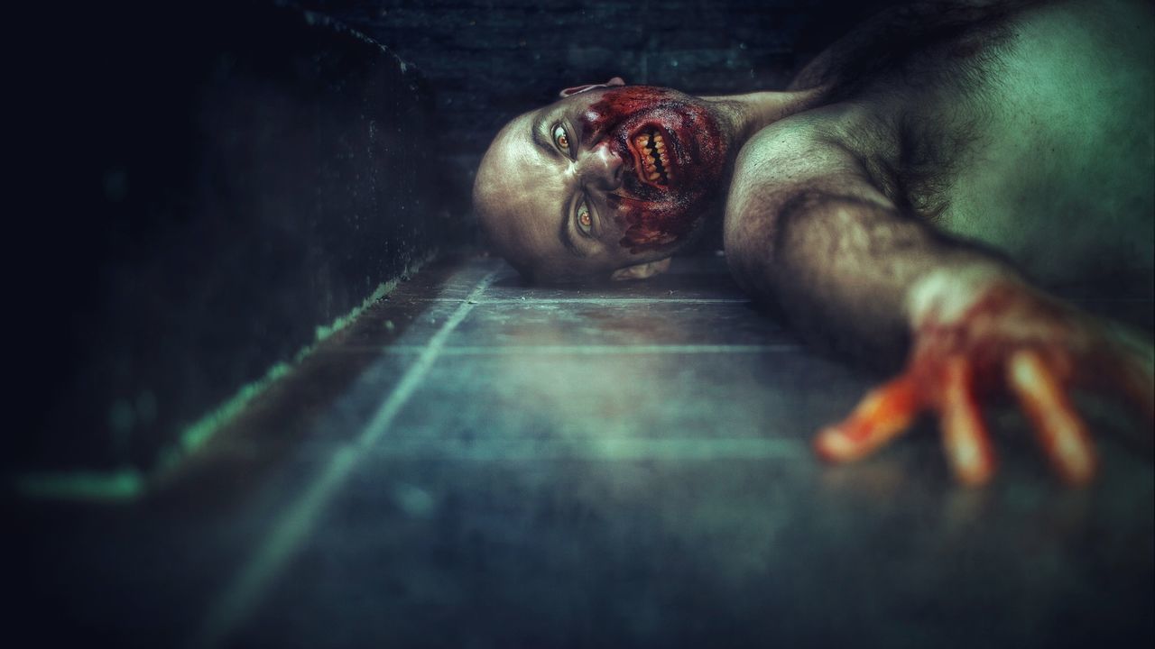 Portrait of zombie lying on floor
